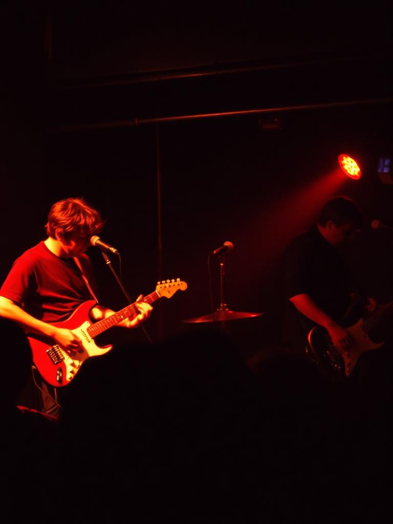 Band performing under red stage light